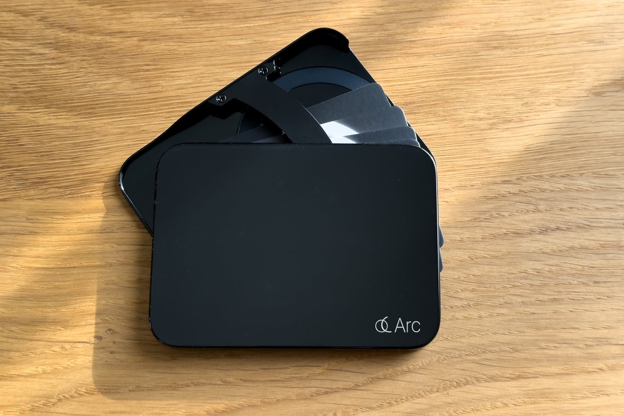 Arc Vault with its cards fanned out behind the Arc logo plate - Luxe Digital