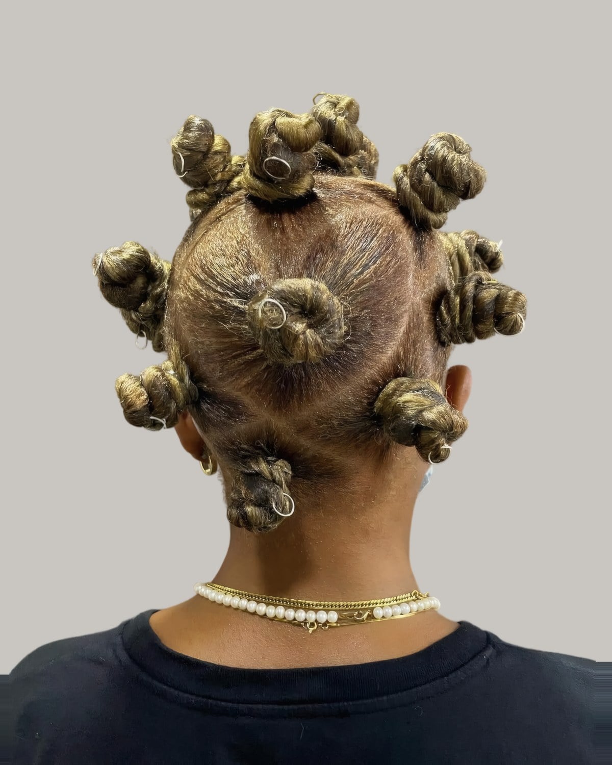 Back view of blonde Bantu knots and a pearl necklace