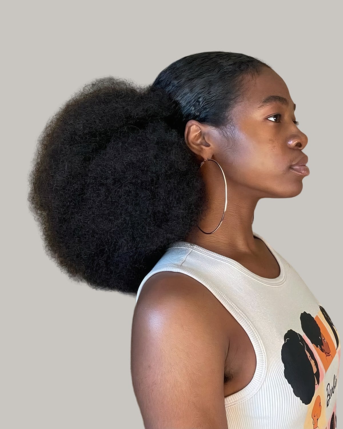 Woman in profile with a large low afro puff at the back of her head
