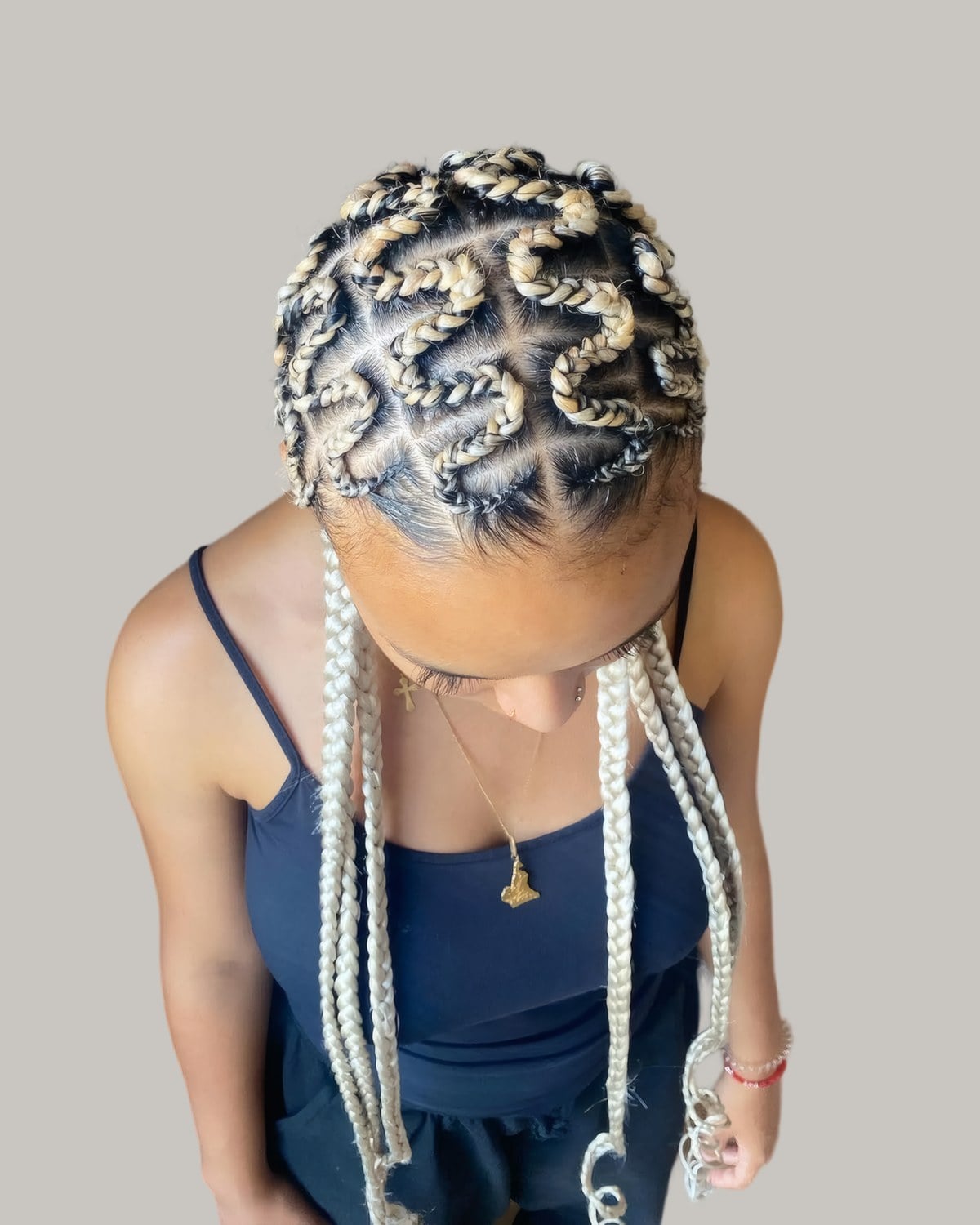 Woman looking down with blonde cornrows in a curved pattern