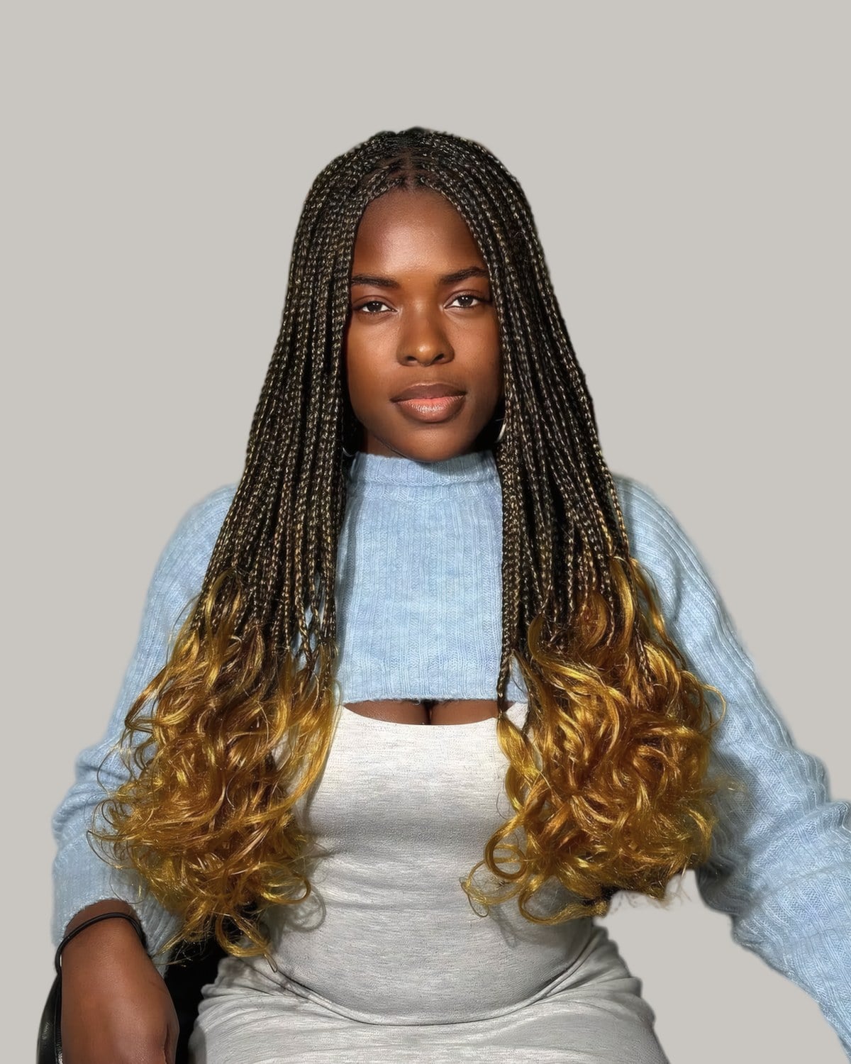 Woman with long ombre box braids fading from black to honey