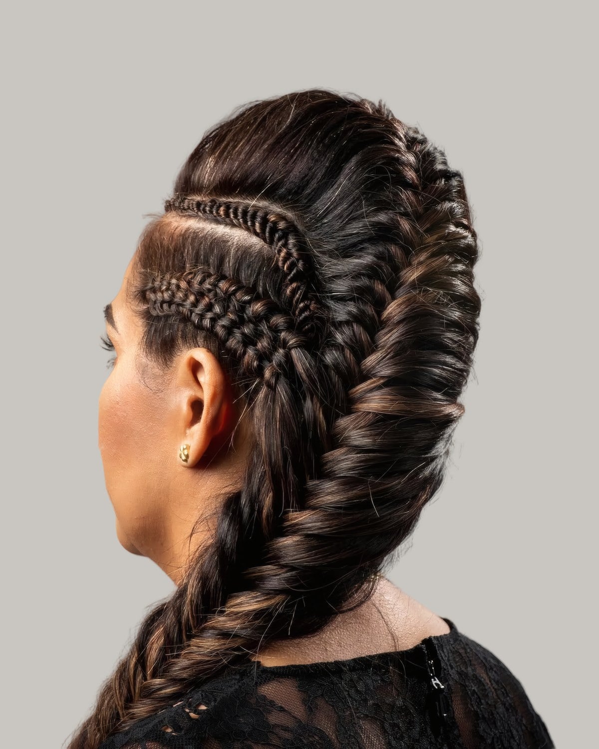 Woman seen from the side with braids swept up into a mohawk