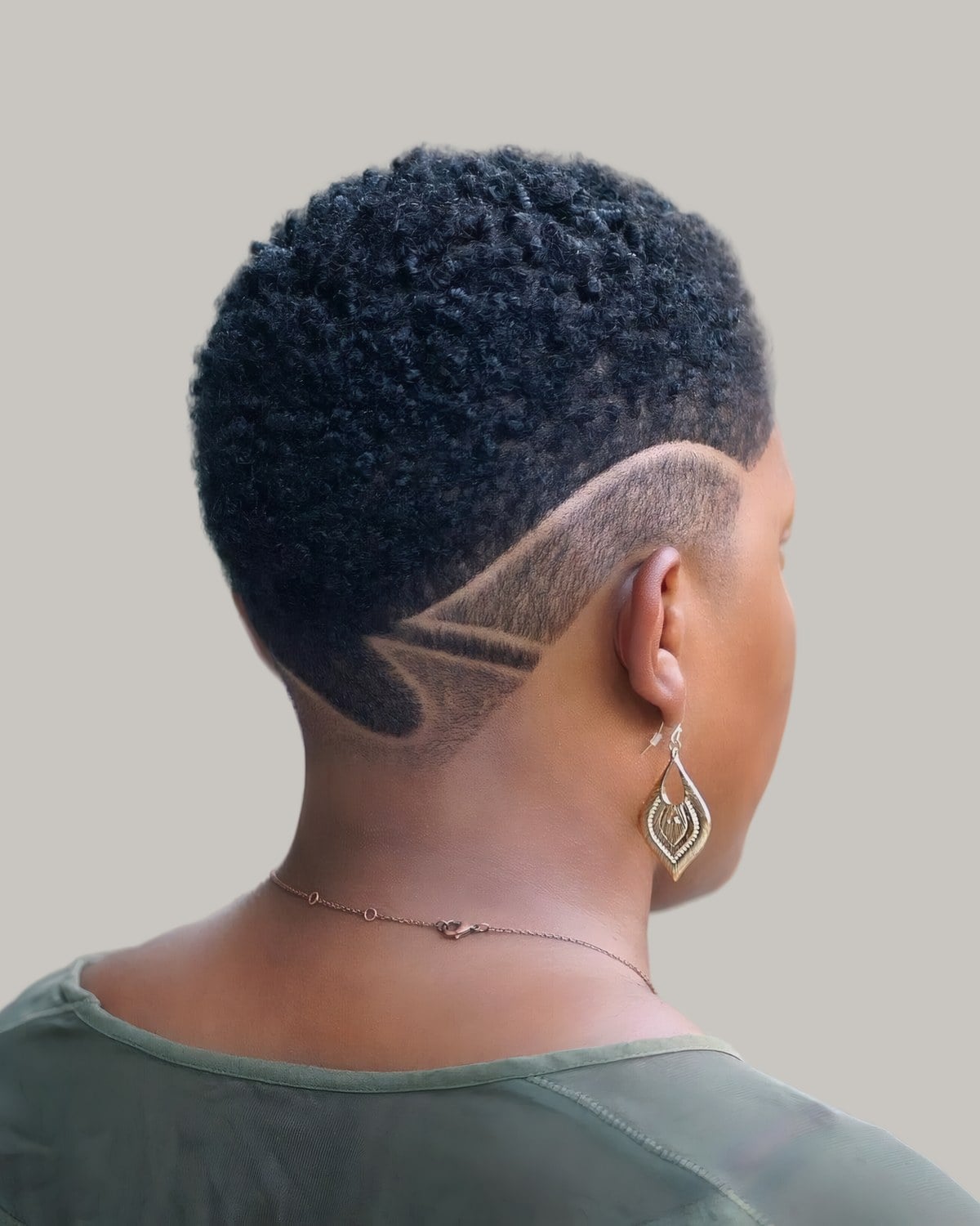Woman seen from behind with a short tapered buzz and a shaved design
