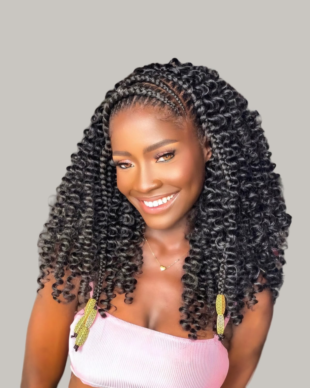 Smiling woman with long spiral crochet curls and braided cornrows at the front