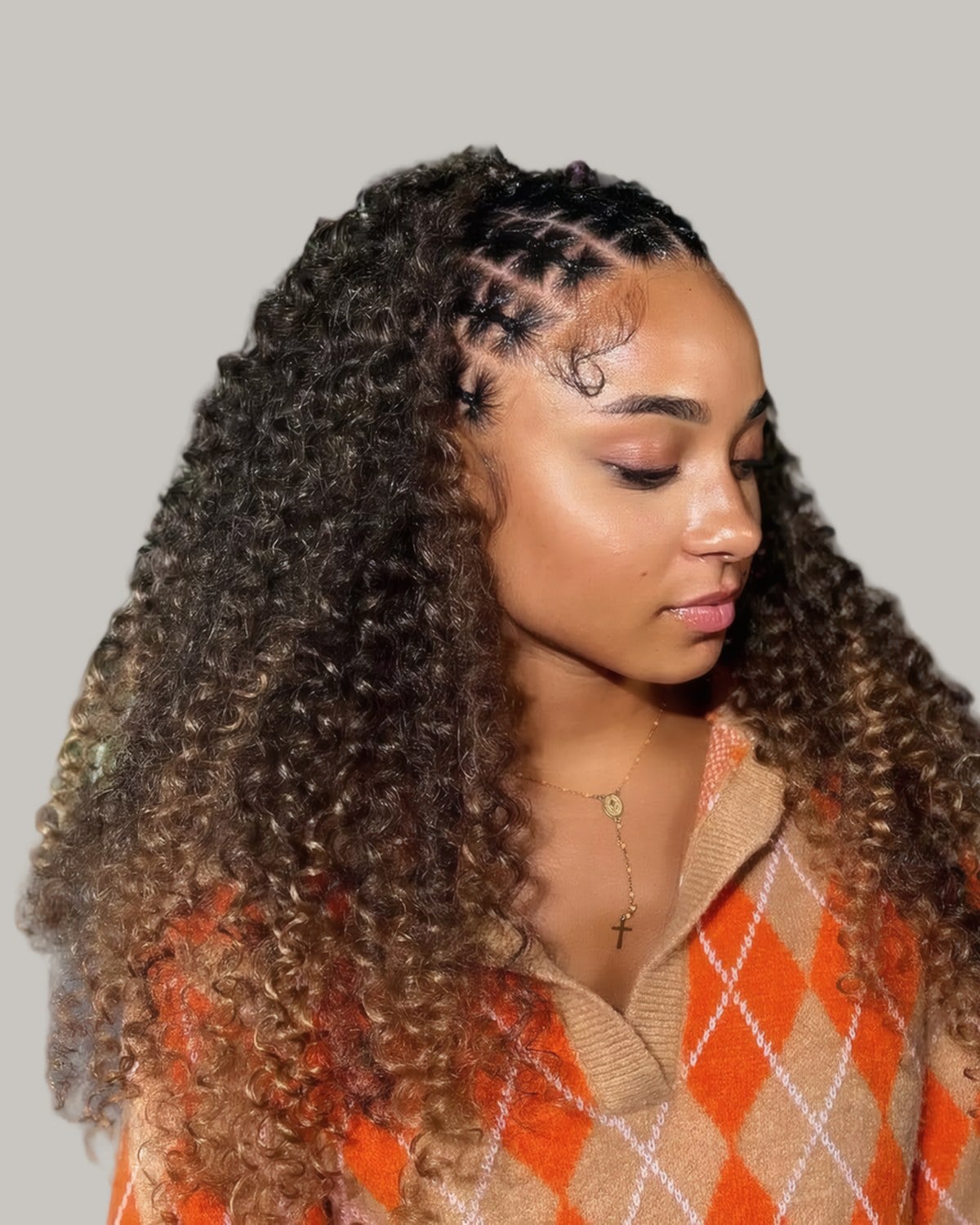 Woman with small braids at the front and long curls behind