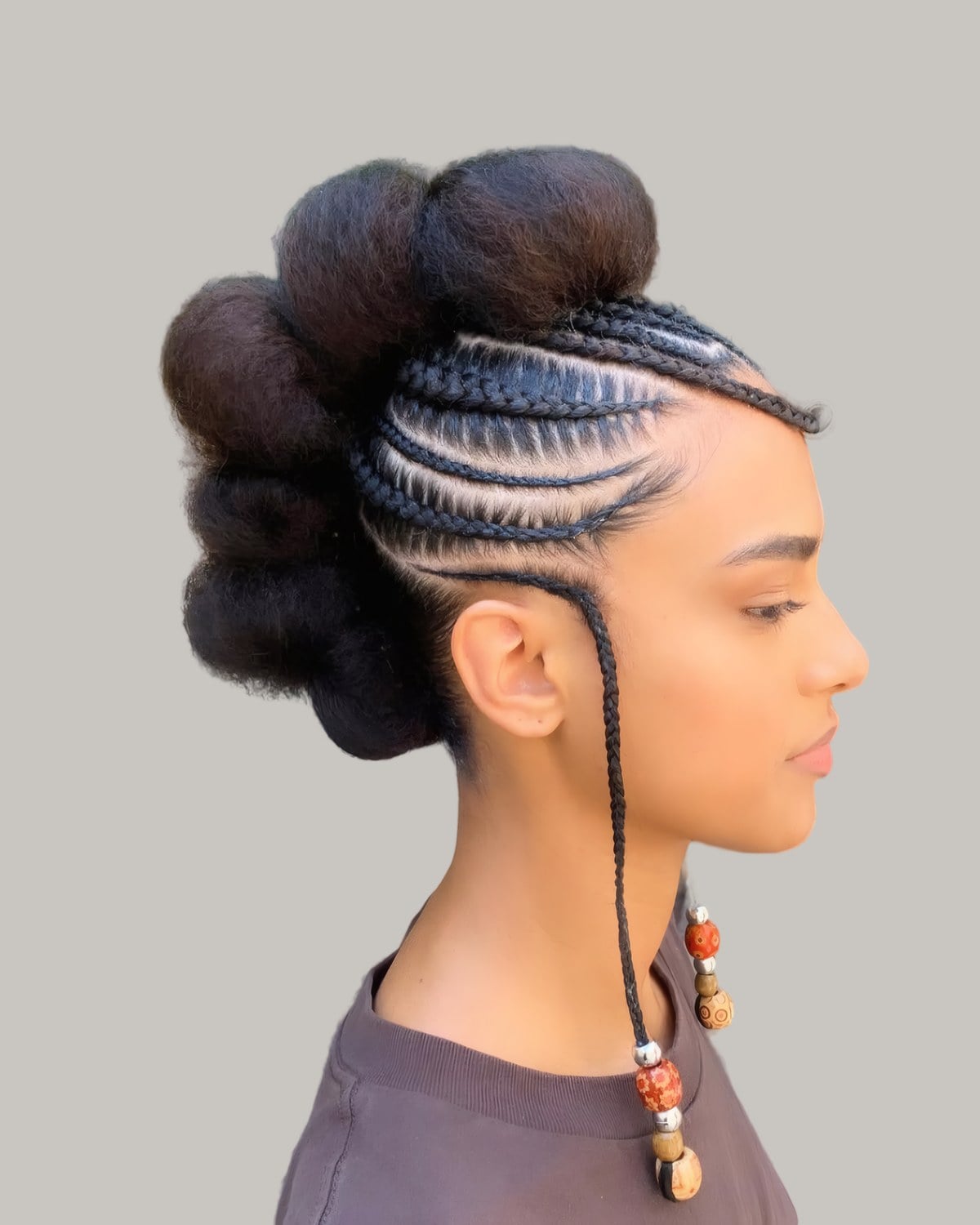 Woman with cornrows at the side and a large puff running down the center
