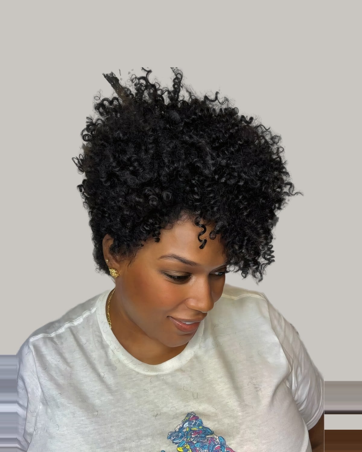 Woman looking down with a short, full curly afro