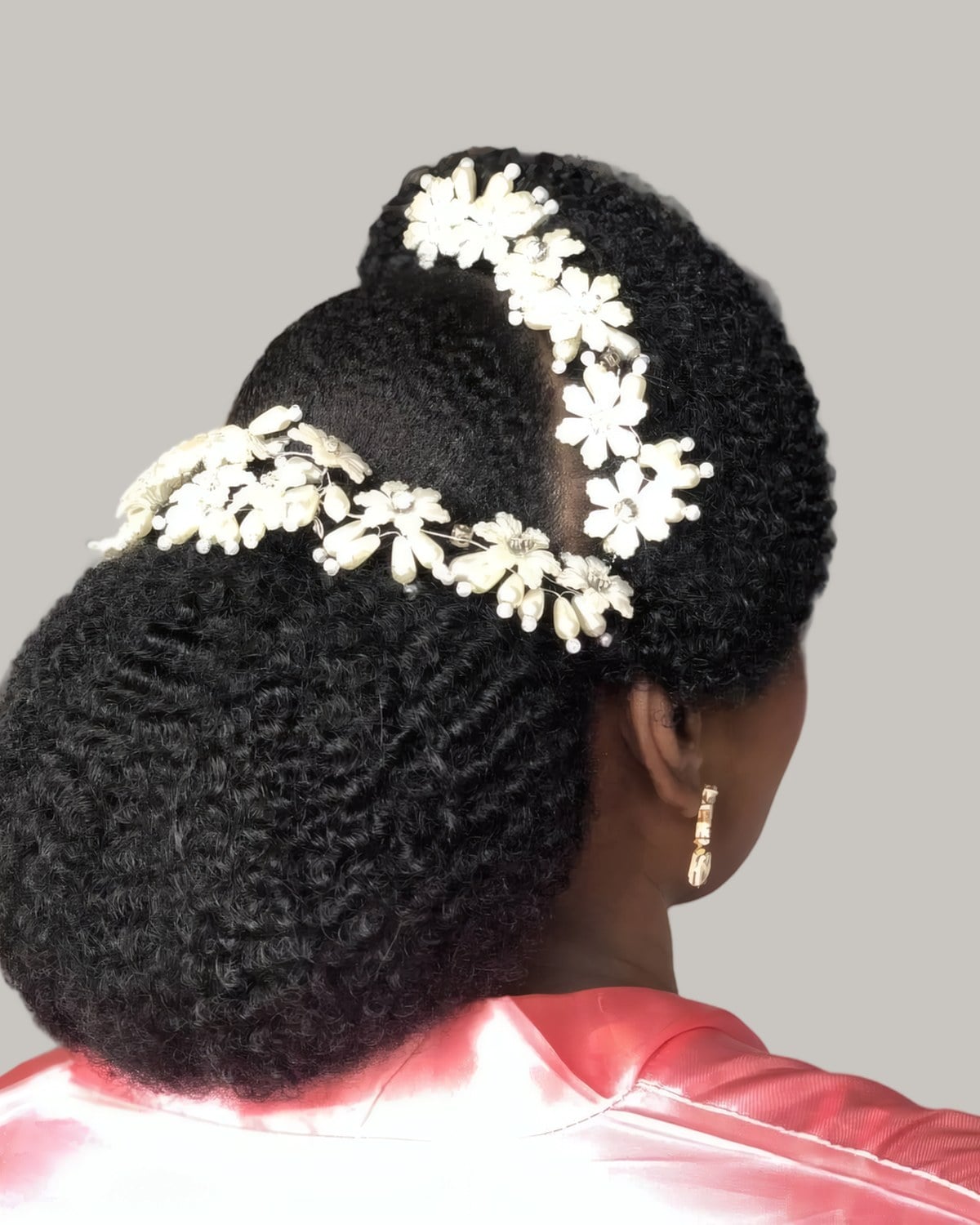 Back view of a smooth natural updo with a white flower vine