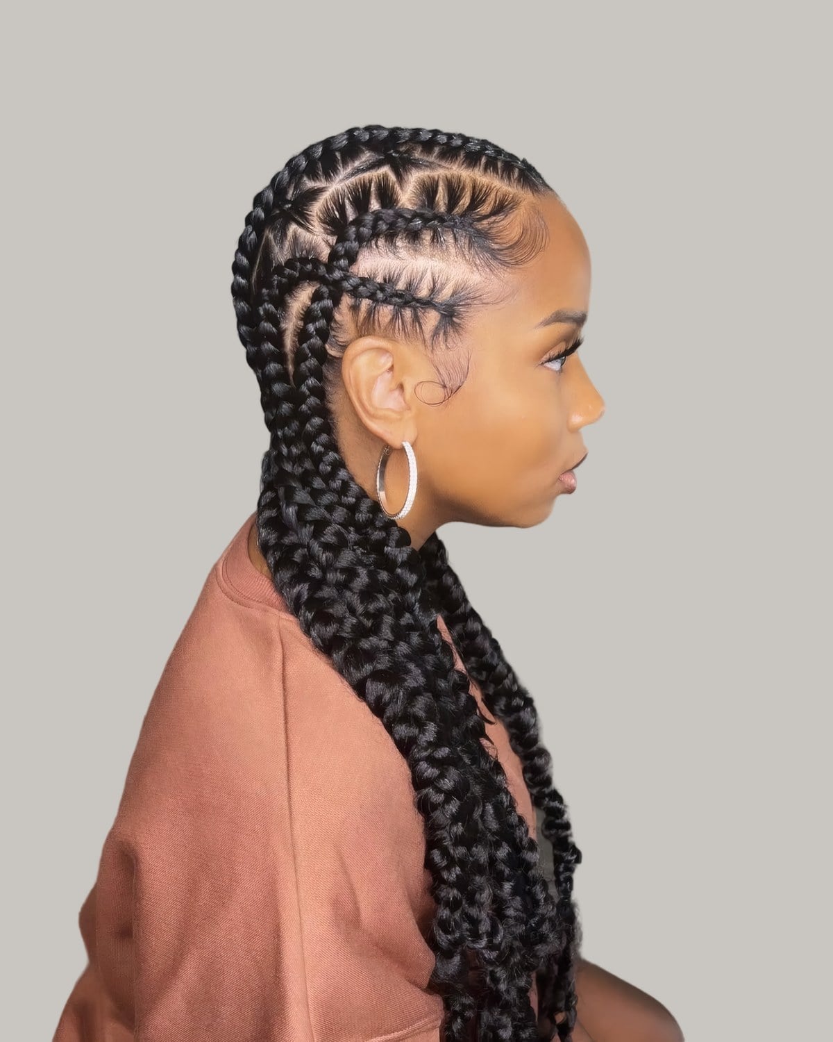 Woman in profile with two thick French braids down her back