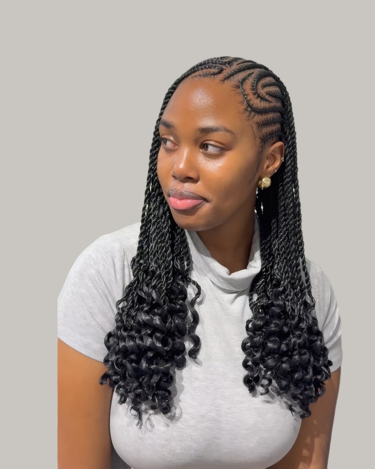 Woman with cornrows on top and long curly-ended braids below