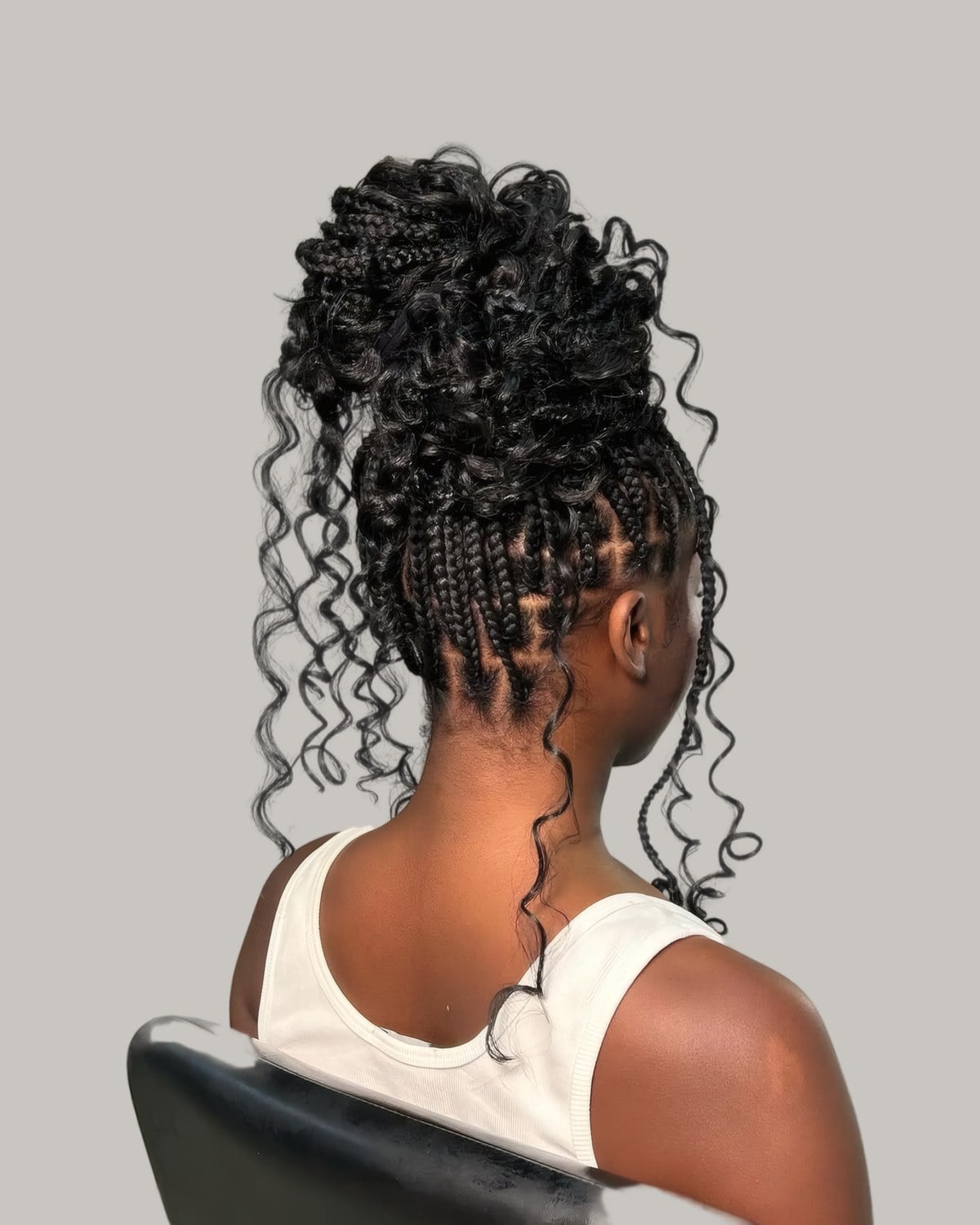 Braids seen from behind, the top half gathered into a curly knot