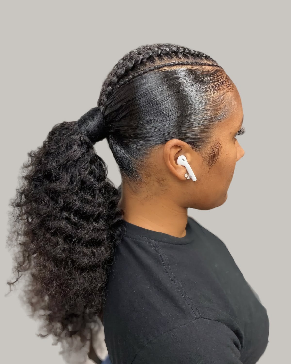 Woman in profile with a sleek low curly ponytail