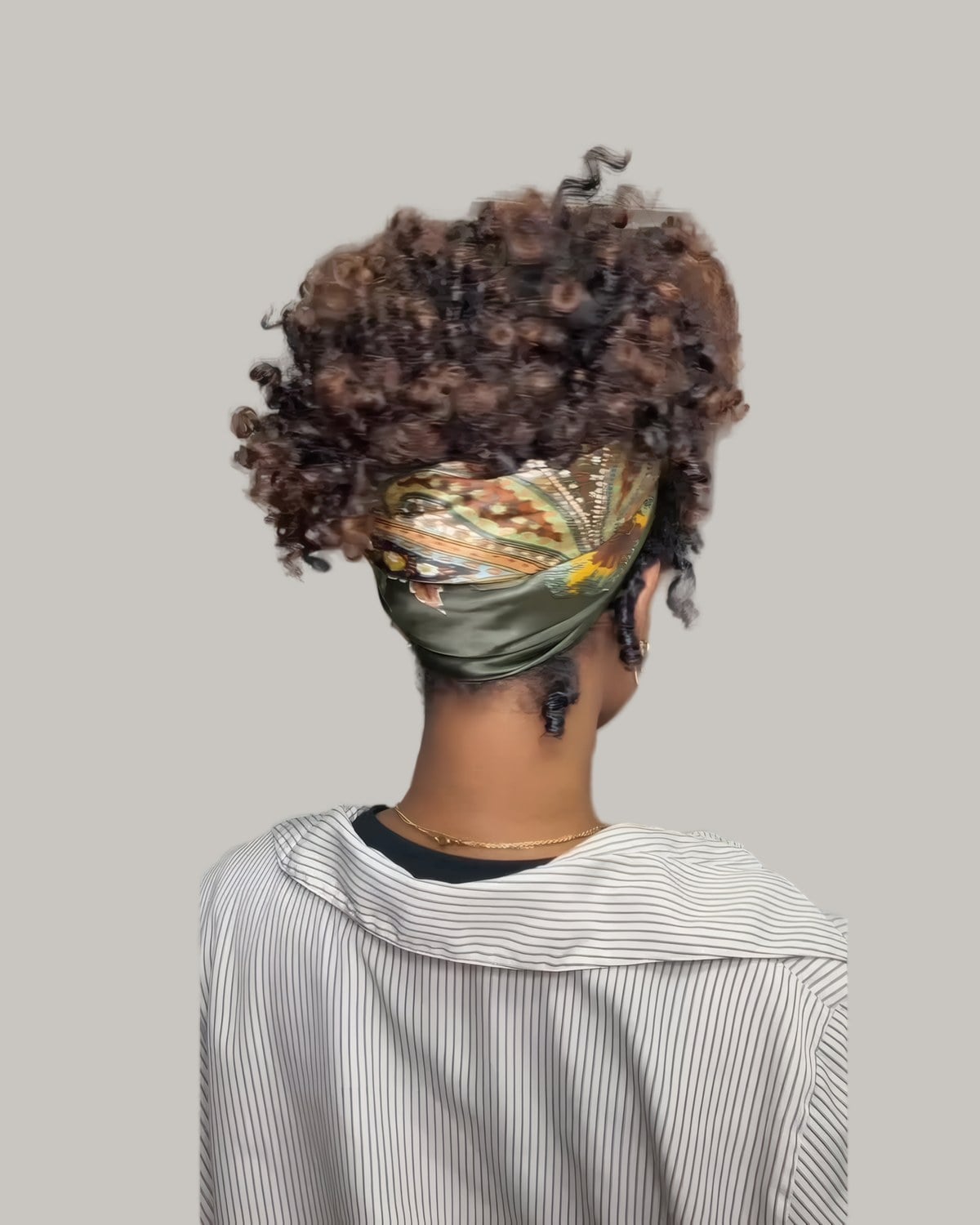 Back view of curls puffed up above a silk scarf headband
