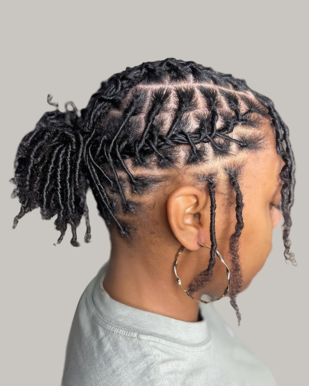 Short locs seen from behind, gathered into a small ponytail