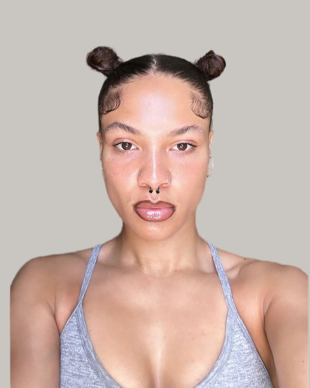 Woman with two mini space buns on a sleek center part
