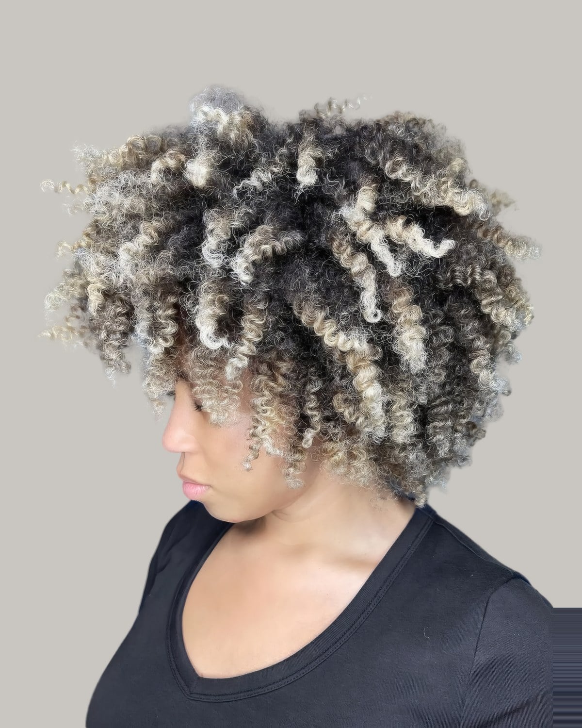 Woman looking down with a short twist-out with blonde ends