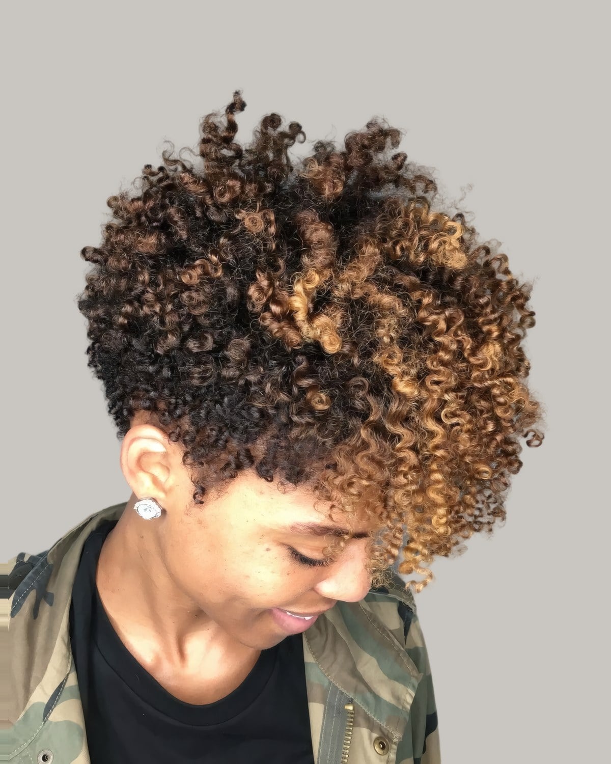 Woman looking down with a short honey brown twist-out