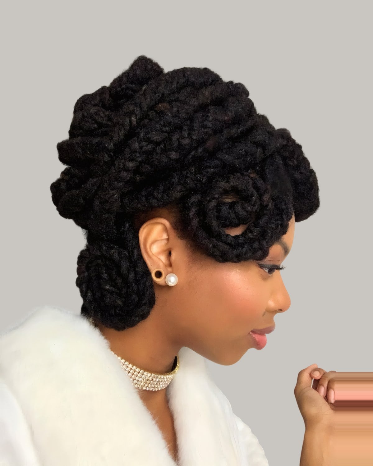 Woman in a white fur collar with thick twists pinned into rolls