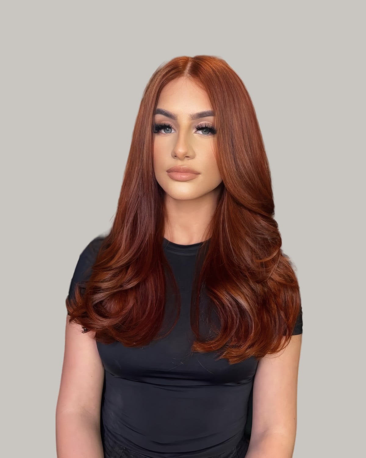 Woman in a black top with long, all-over copper hair