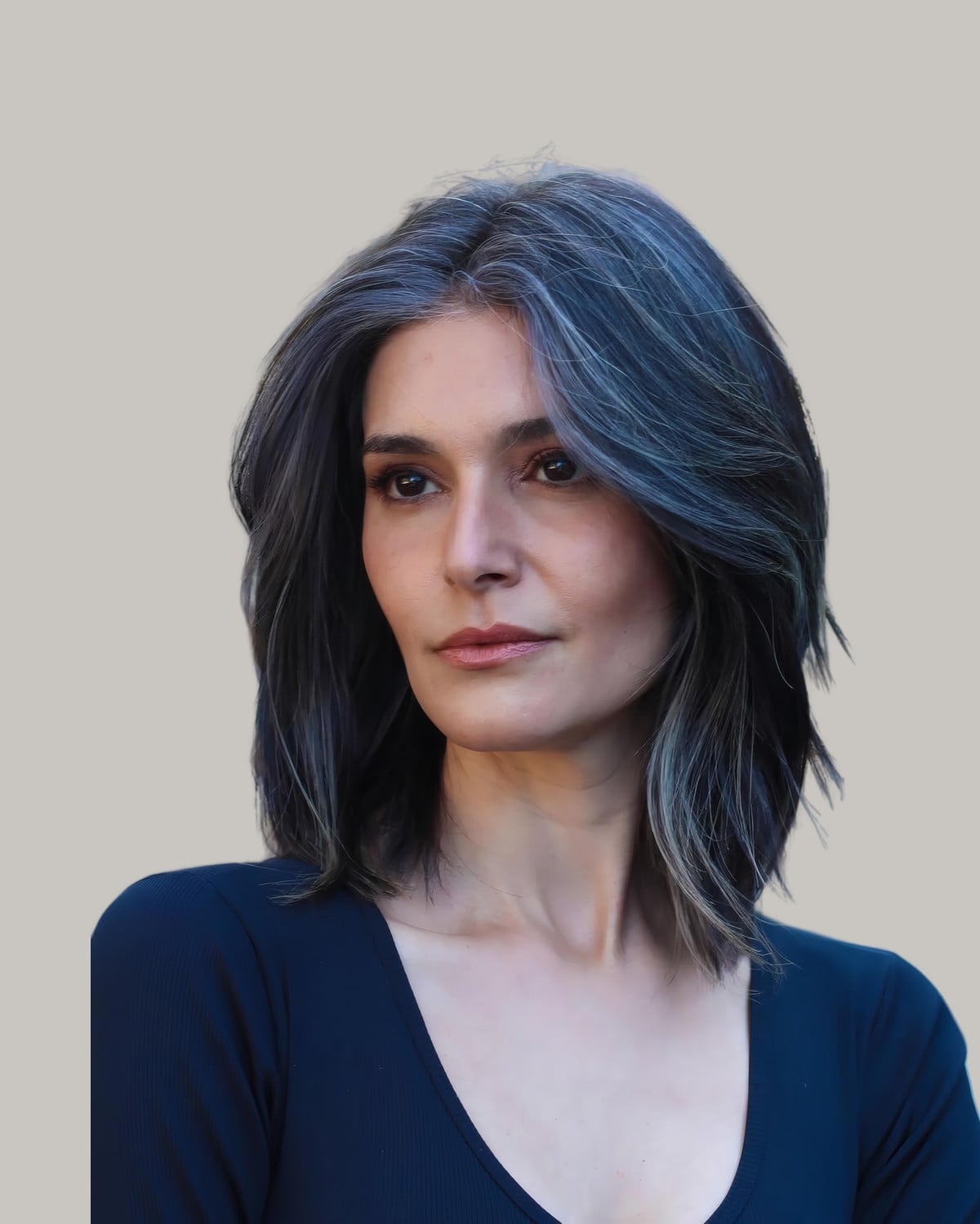 Woman in a navy top with shoulder-length dark hair and silver streaks