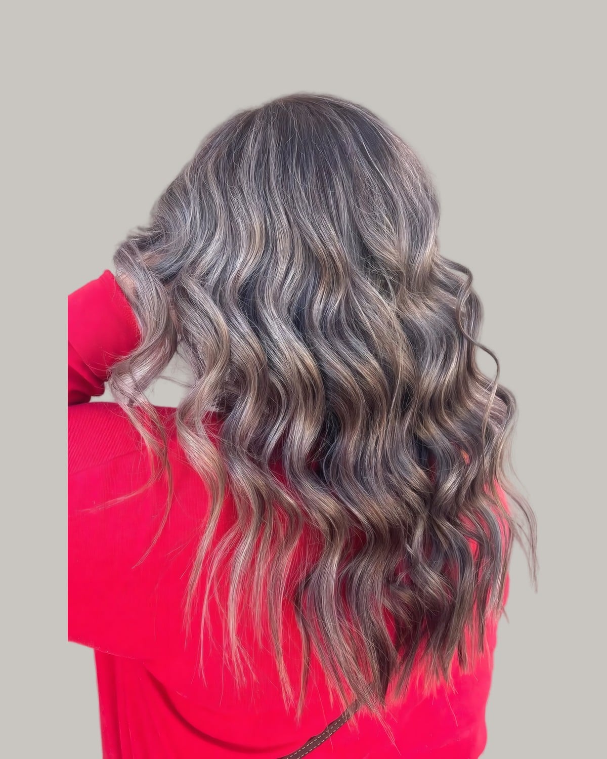 Back view of long gray curls with darker strands underneath