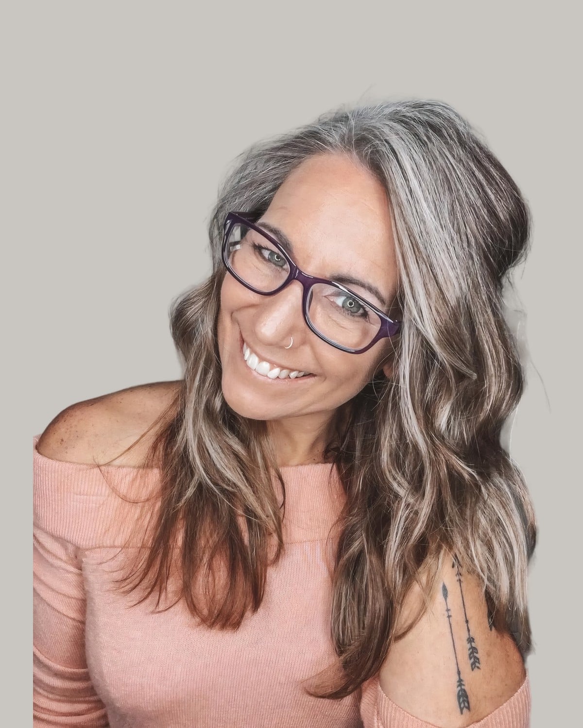 Smiling woman in glasses with long waves blending from brown to gray