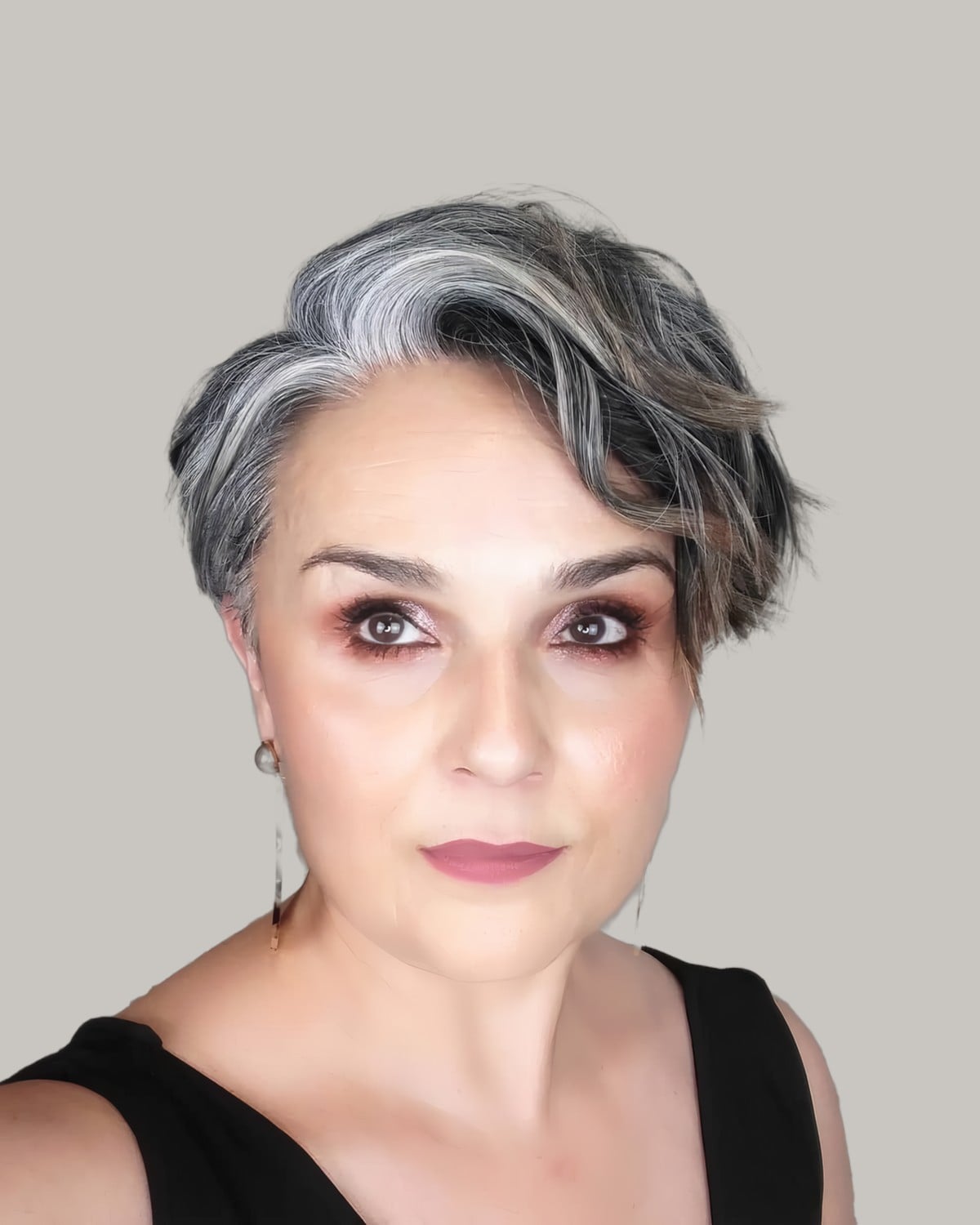 Woman with a short wavy crop and a silver sweep at the front