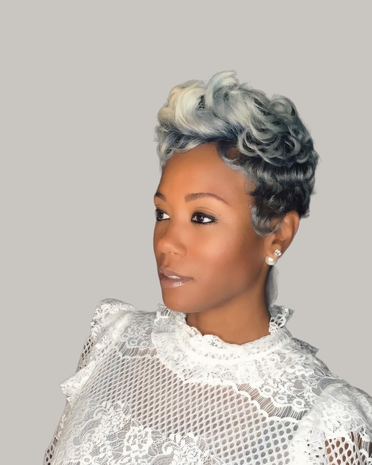 Woman with a short curly pixie, silver on top and dark at the sides