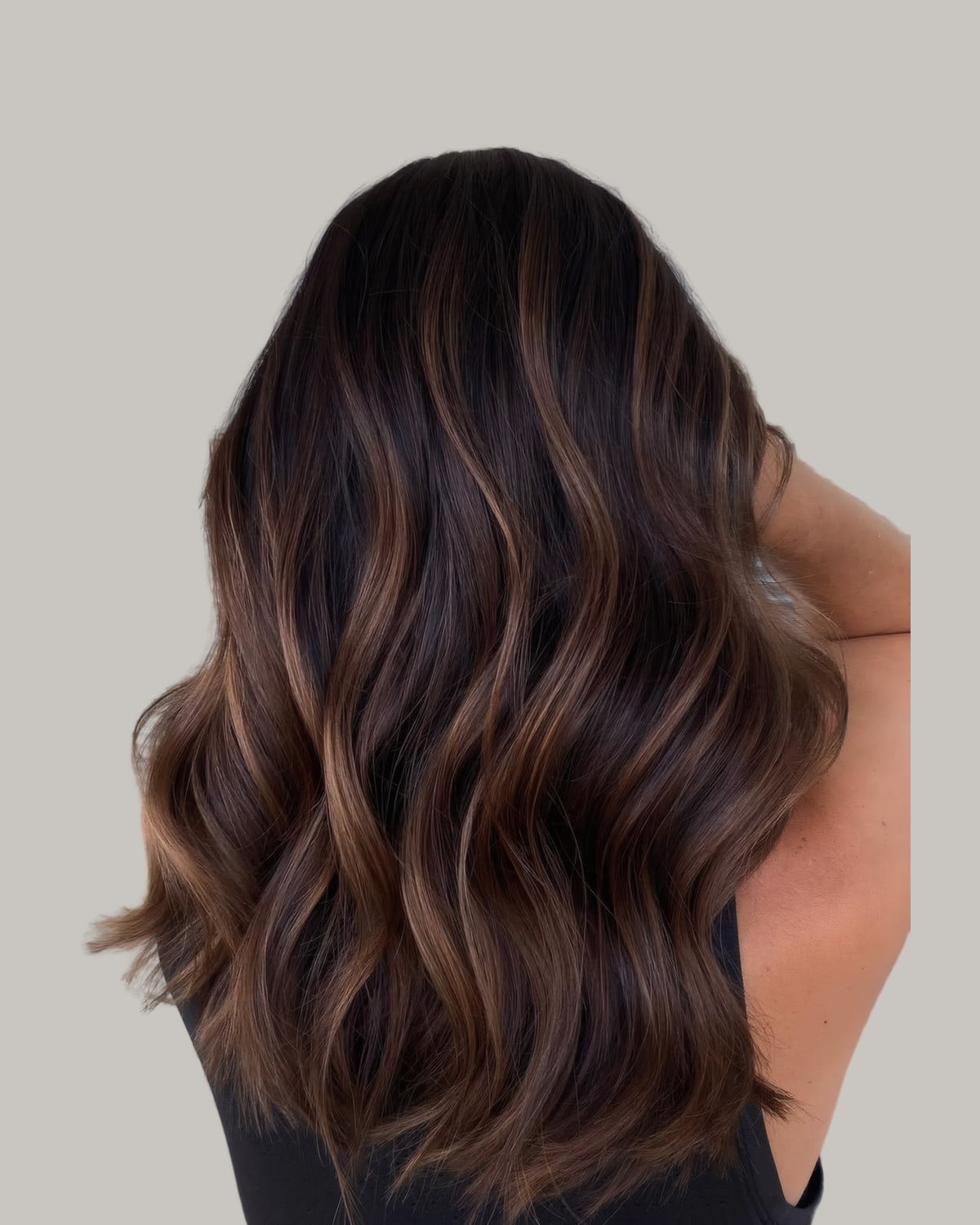 Back view of dark hair with soft caramel pieces