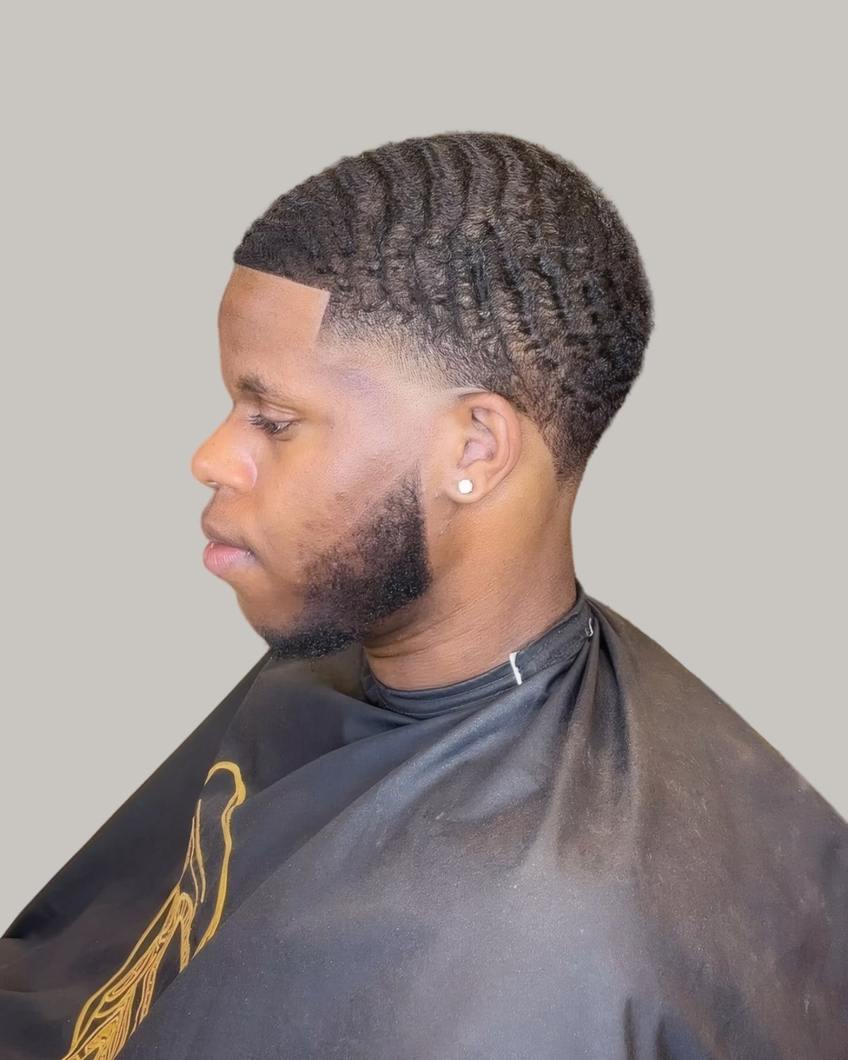 Bearded man with waves and a temple fade, seen in profile