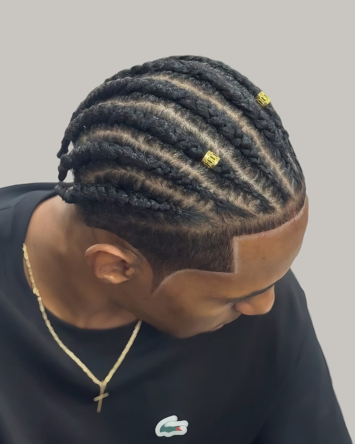 Man with cornrows and a tapered side, looking down