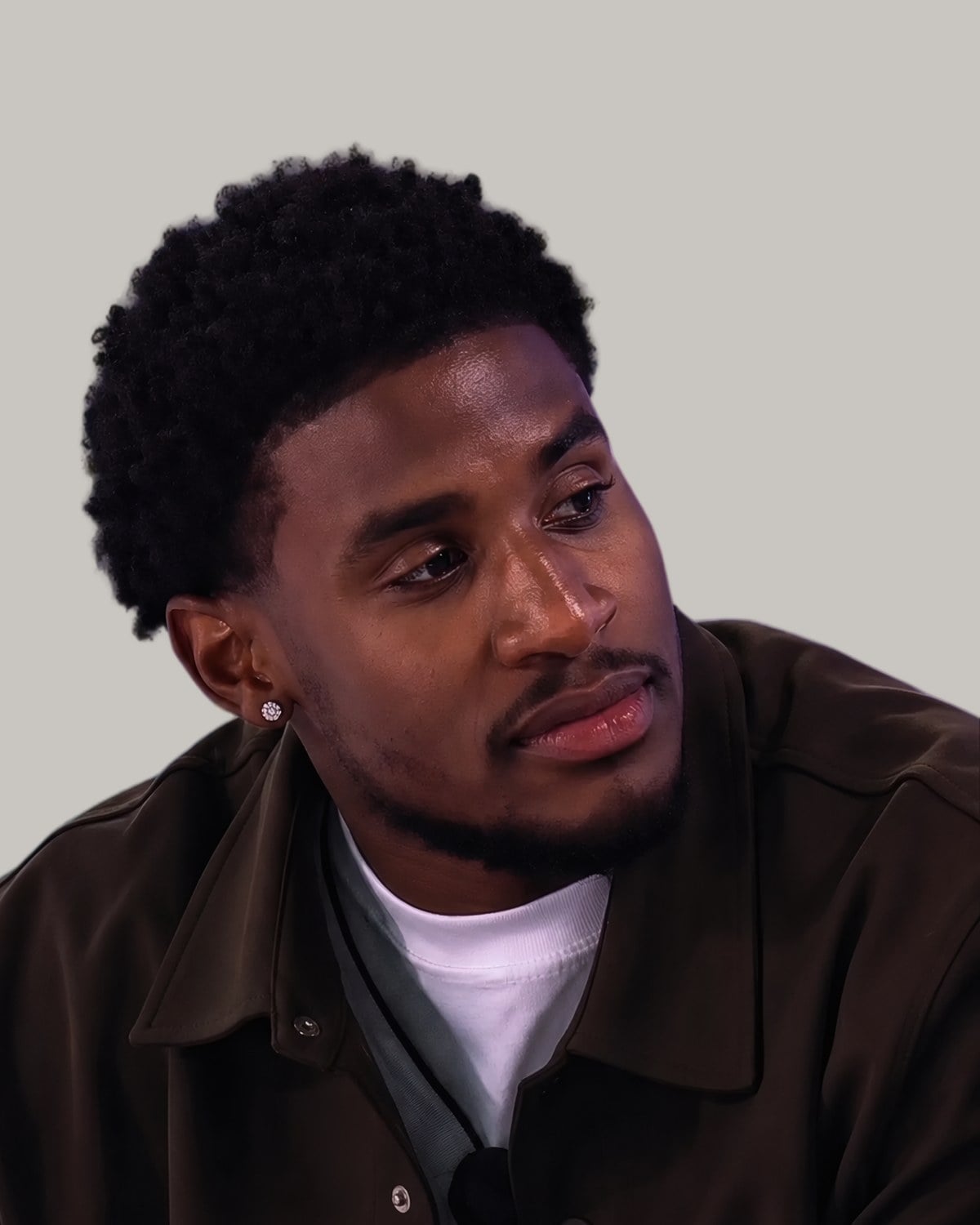 Man with short defined curls, seen at an angle