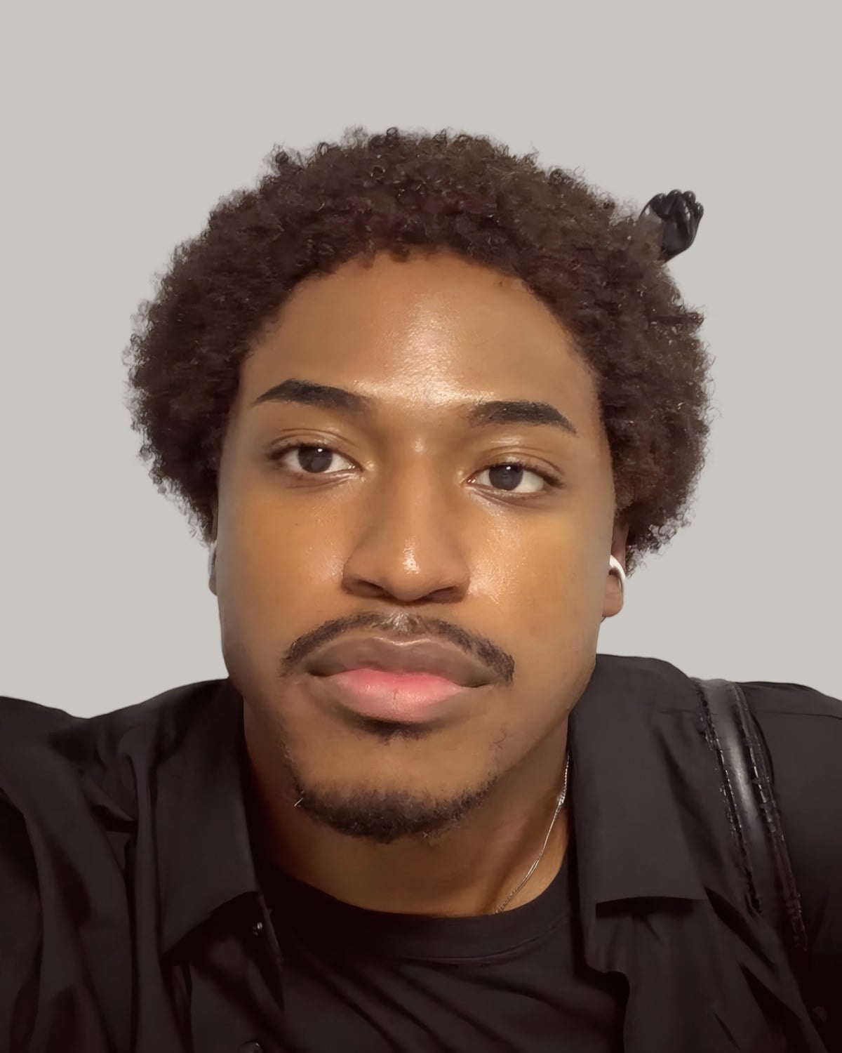 Man with short curls and a mustache, seen from the front