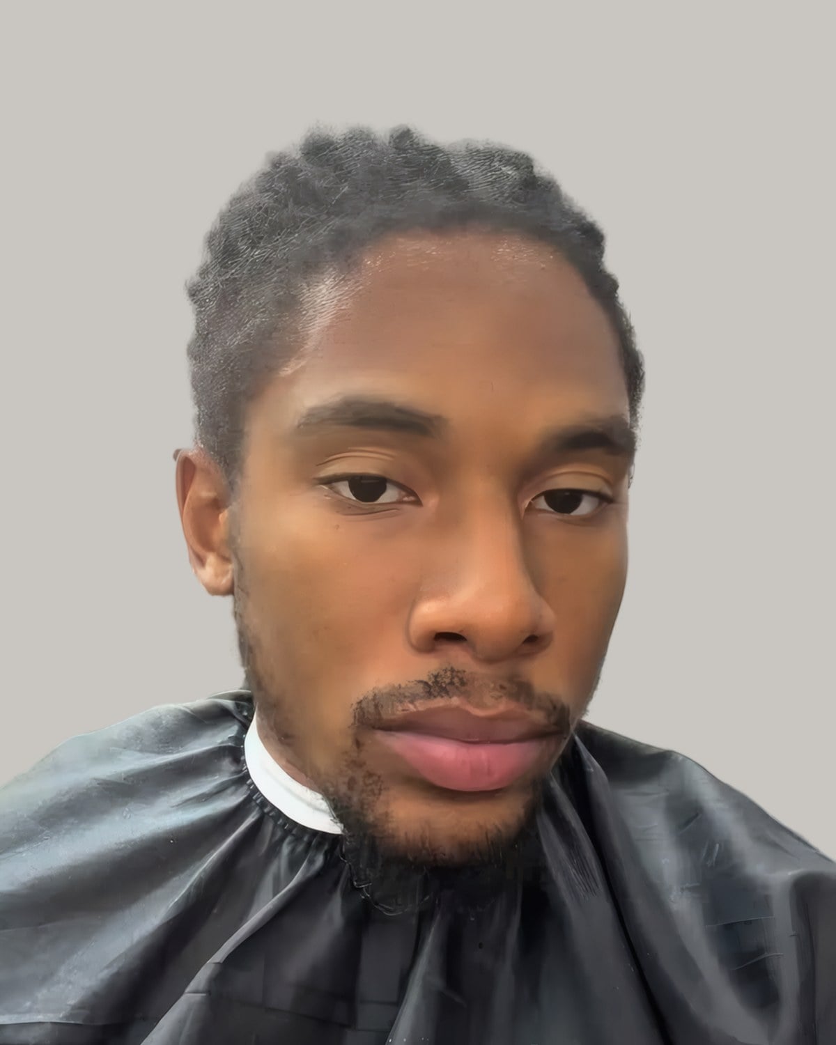Bearded man with locs pulled back, seen from the front
