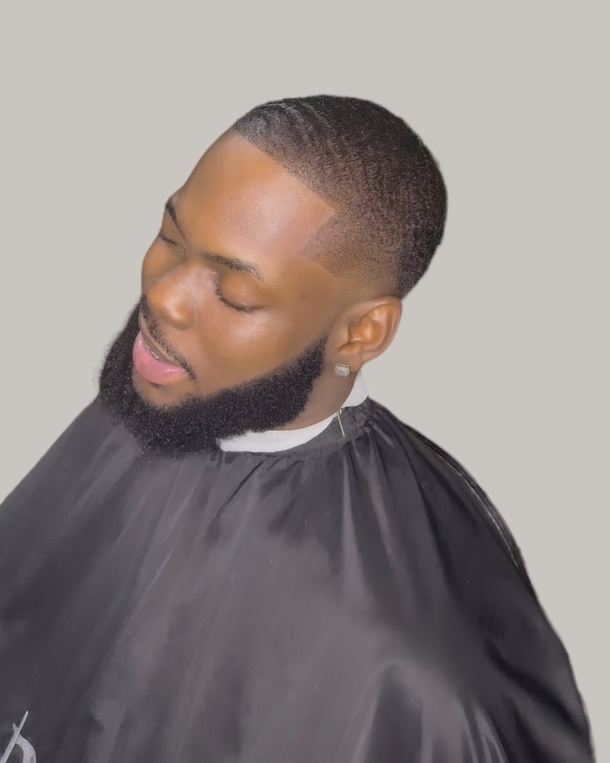 Man with a full beard and a short low cut, seen in profile
