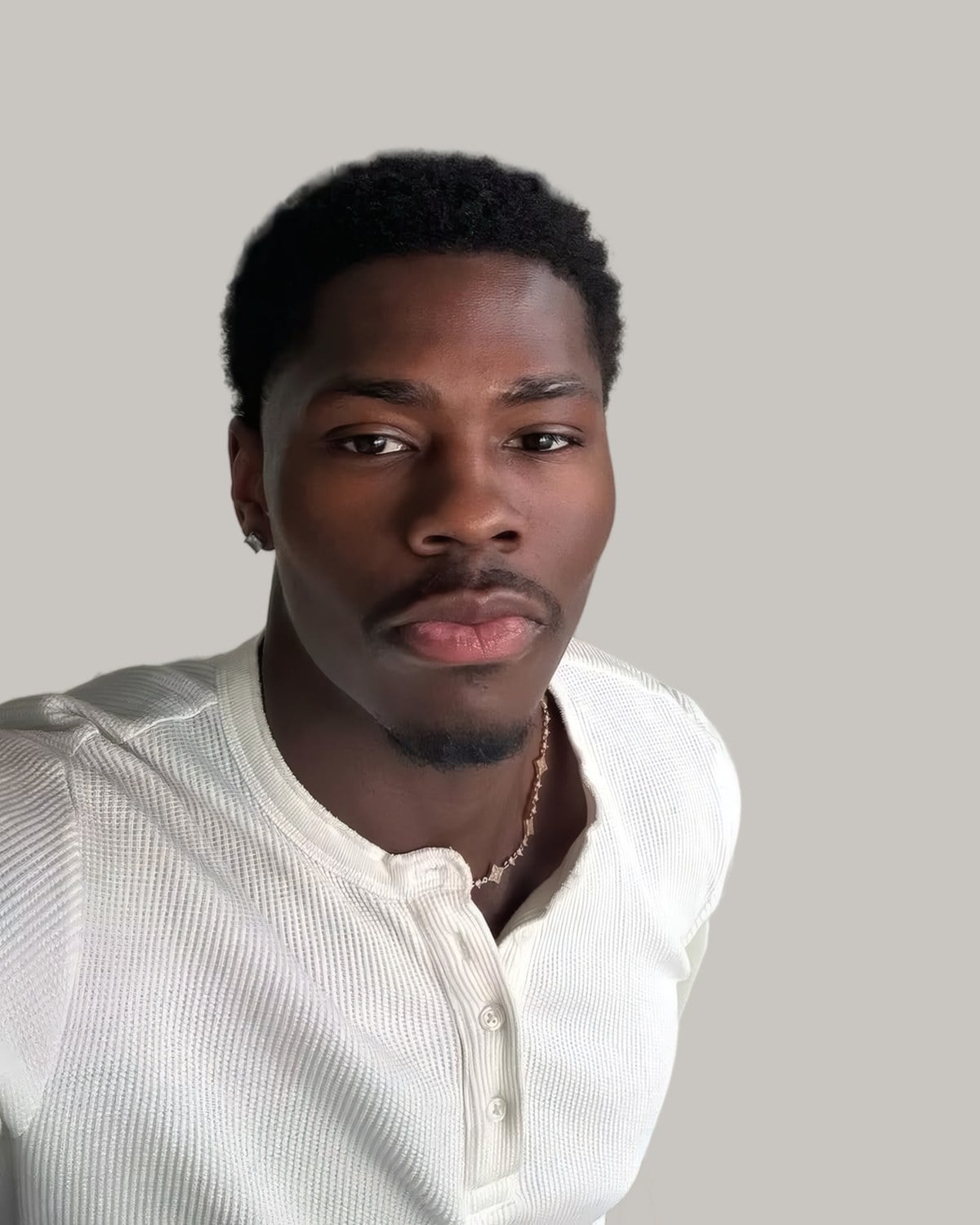 Man with a short afro and a low taper, seen from the front