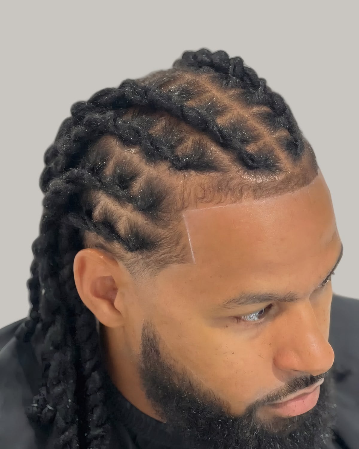 Bearded man with two-strand twists, seen at an angle