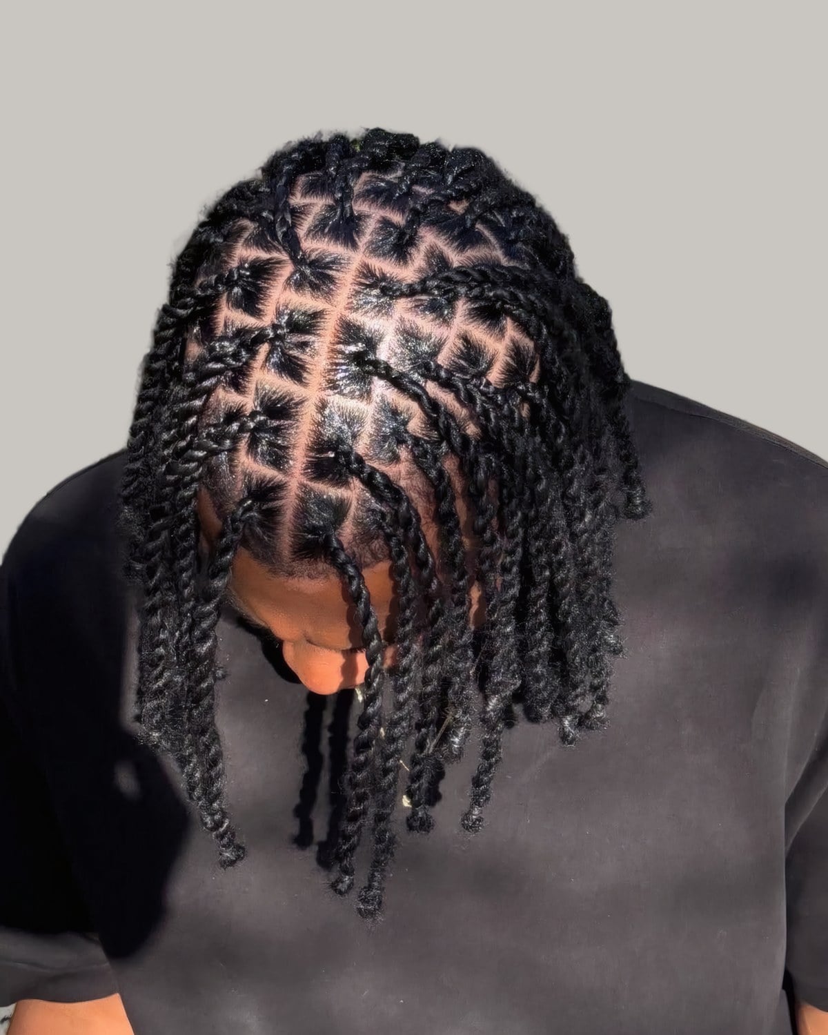 Man with two-strand twists and square parts, looking down