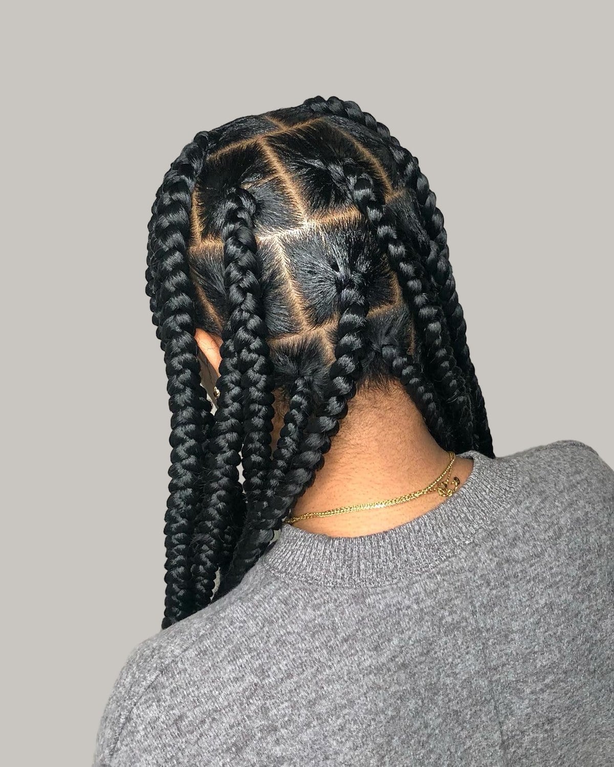 Back view of long black jumbo box braids over a gray sweater