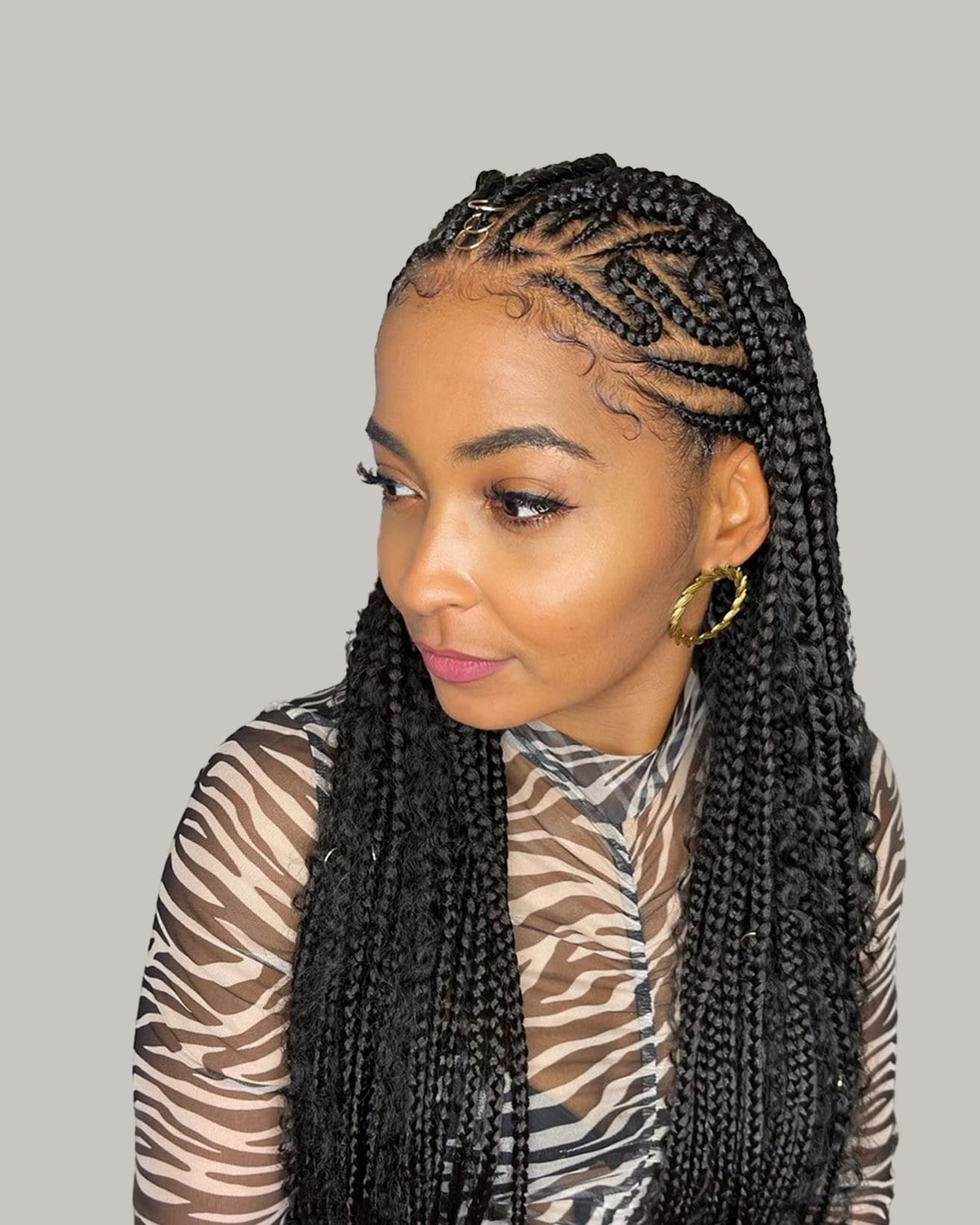 Woman looking to one side, black tribal braids with a zigzag pattern at the hairline