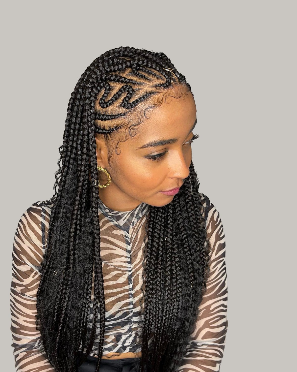 Woman in a zebra-print top with black tribal braids and zigzag cornrows at the front