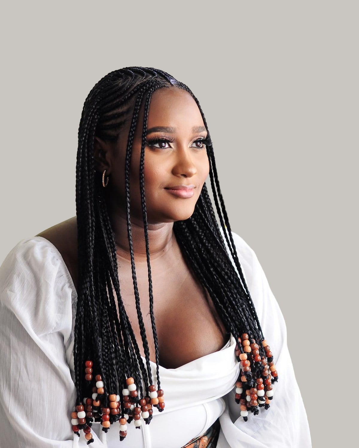 Smiling woman in a white blouse with black tribal braids and beaded ends