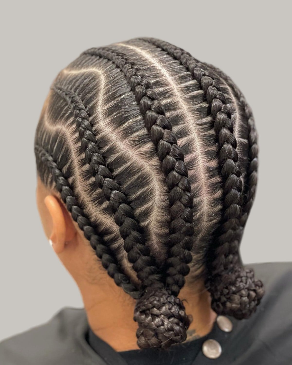 Back view of wavy stitch braids ending in two buns at the nape