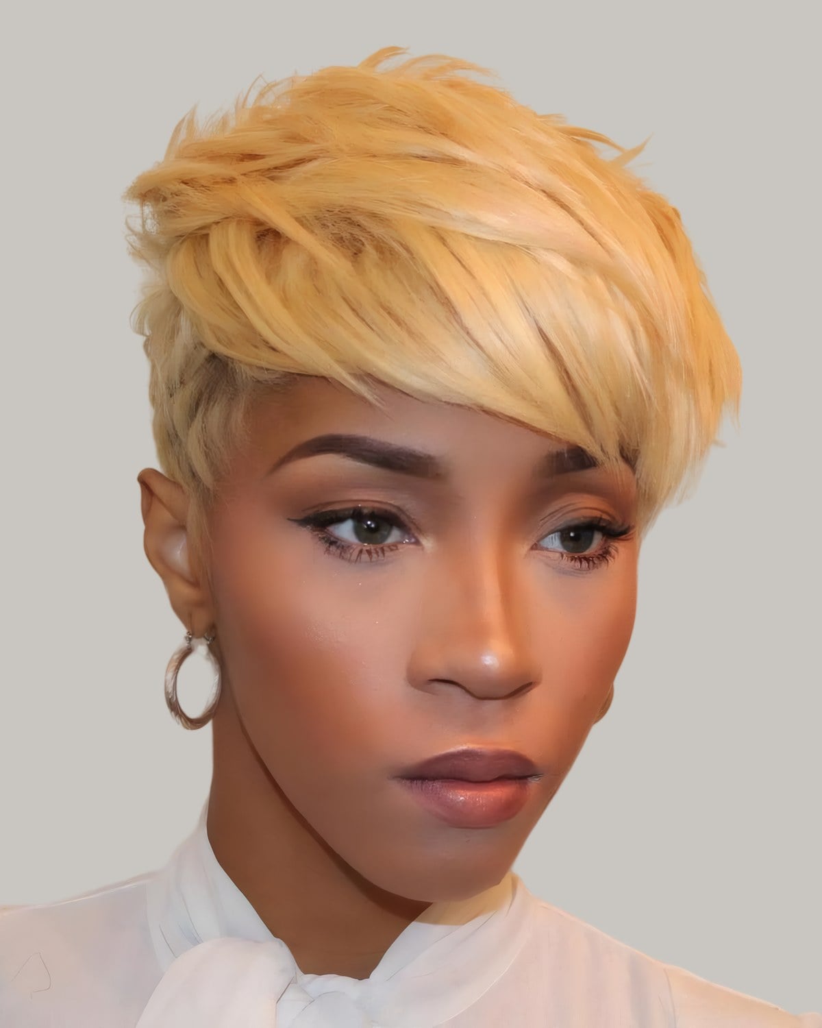 Woman with a blonde pixie and a long fringe, hoop earrings