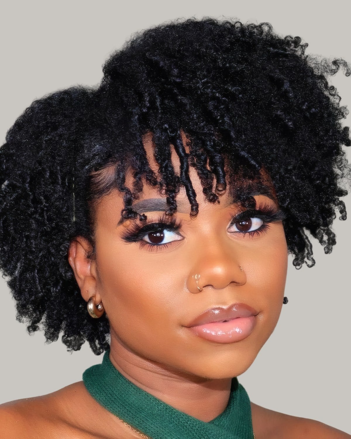Smiling woman with a round curly bob and curly bangs