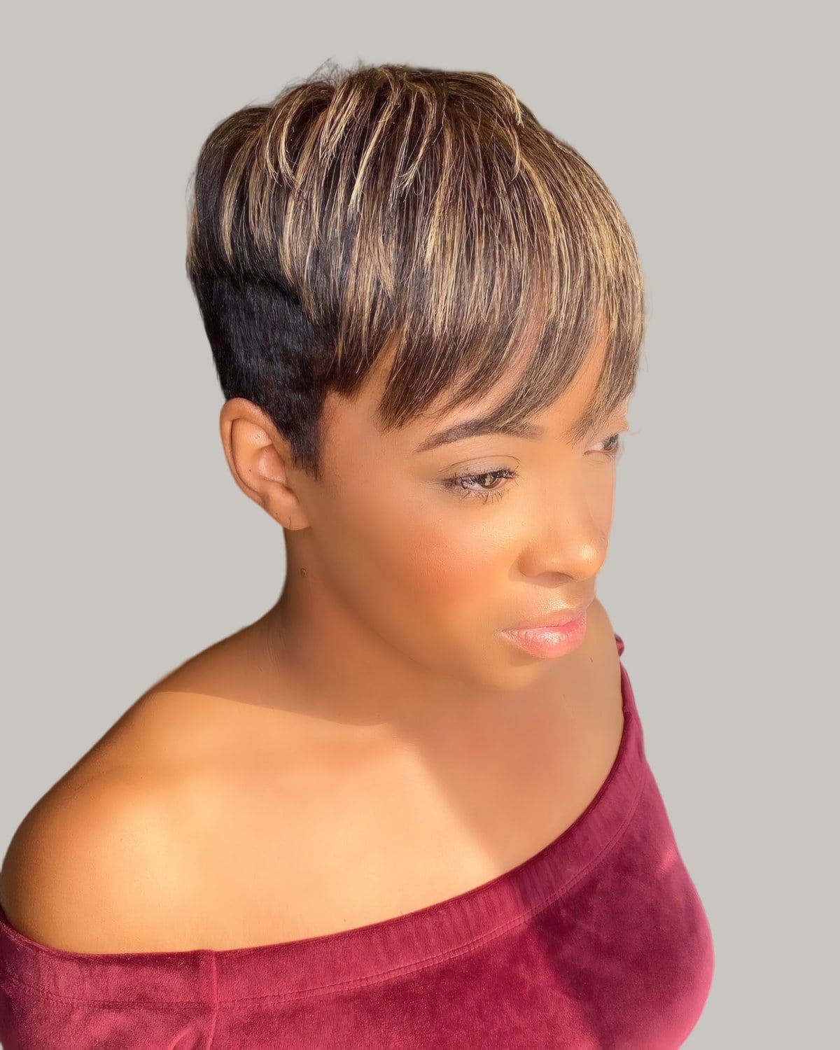 Woman with a short layered pixie and a golden fringe, eyes closed
