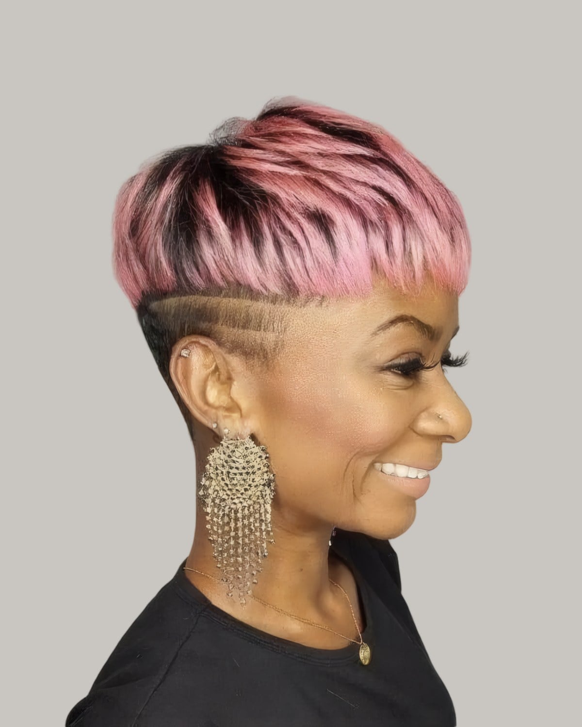 Smiling woman with a pink bowl-shaped top over a shaved side with a design