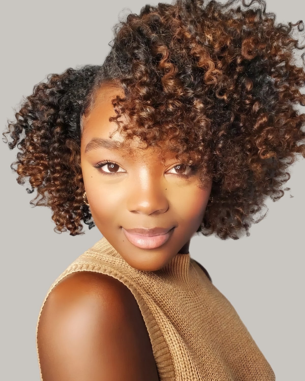 Smiling woman with a brown curly bob swept to one side