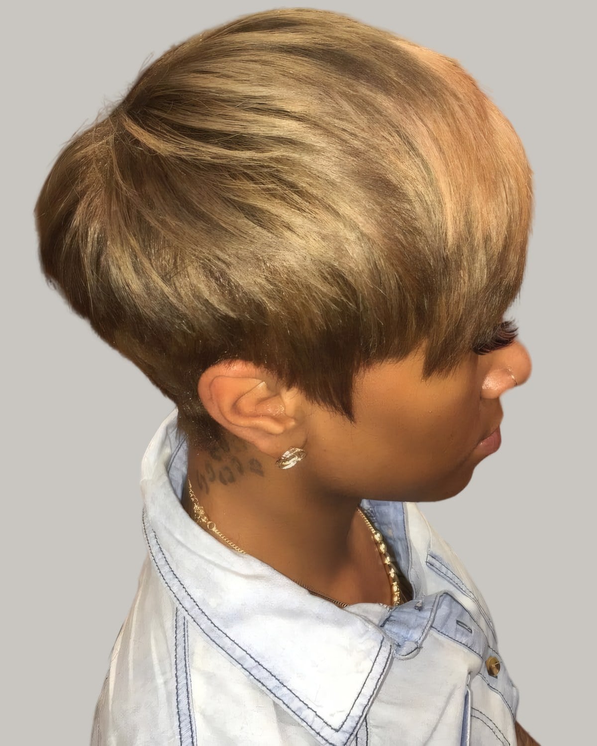 Woman with a honey blonde rounded pixie seen from the side