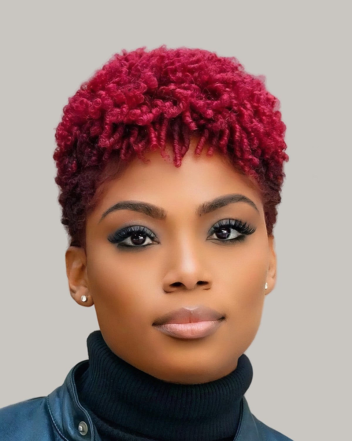 Woman with short cherry red coils in a black turtleneck